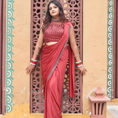 This stunning red pre-draped saree is perfect for a newlywed look or a festive party. It comes with a heavily sequined blouse and is incredibly easy and comfortable to wear.