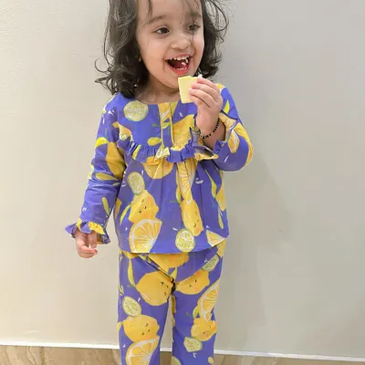 A happy toddler in her comfy lemon-print nightwear. Made from butter-soft cotton, this pajama set is designed for maximum comfort, making bedtime a little more cheerful.