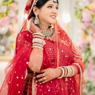 A radiant bridal portrait. The bride's happy, candid expression and the beautiful floral background come together perfectly in this shot.