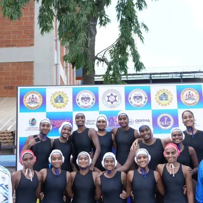 Our junior girls team in their swimwear and caps, ready for competition at the 51st Junior National Waterpolo Championship. This photo, taken with their coaches, shows their focus and team spirit before a match.
