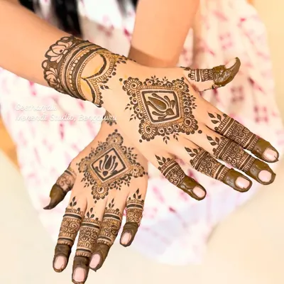 A modern and chic semi-bridal design. This look features a central framed lotus on the back of the hand, with detailed finger work and a heart motif on the wrist.