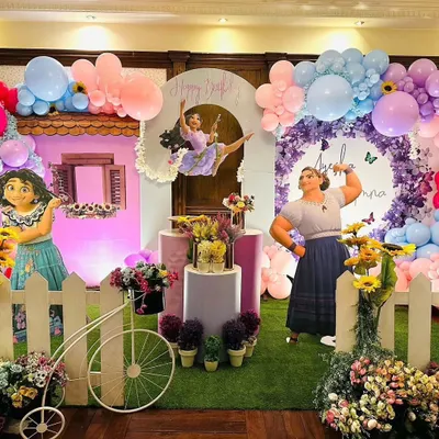 A vibrant and magical Encanto themed birthday party, featuring a full stage setup with character cutouts, a colorful balloon arrangement, and floral details that bring the movie to life.