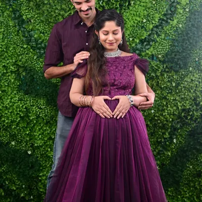 A beautiful moment between parents-to-be during their maternity shoot. The mother is wearing a lovely off-shoulder purple gown from my rental collection, perfect for indoor studio sessions.
