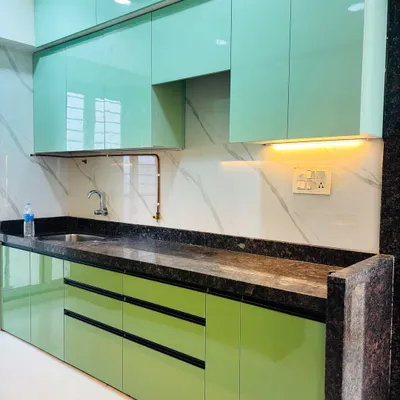This parallel kitchen features mint green high-gloss cabinets for a fresh and modern look. I've paired it with a dark granite countertop and a white marble-patterned backsplash for a beautiful contrast.