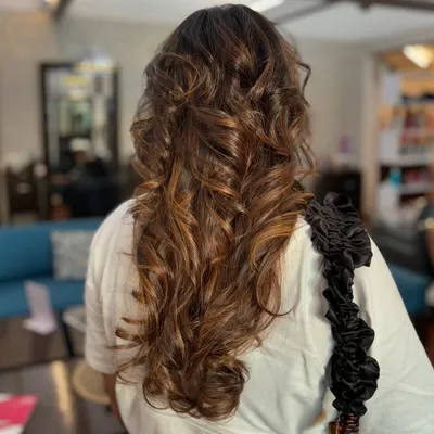 A perfect example of a beautiful caramel balayage. Our stylist hand-painted these highlights to create a seamless, natural-looking blend, finished with soft curls to showcase the dimension.