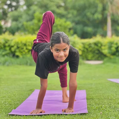 Twist, twist. This young student shows great form and focus in a twisting arm balance, building strength and coordination.
