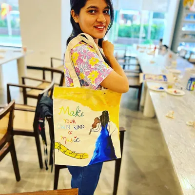 A participant proudly displays her hand-painted tote bag. These workshops are one of my most popular offerings, as everyone creates a unique and practical item to take home.
