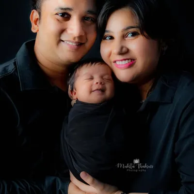 The purest joy on a newborn's face, nestled safely between his loving parents. A classic family portrait that you will cherish forever.
