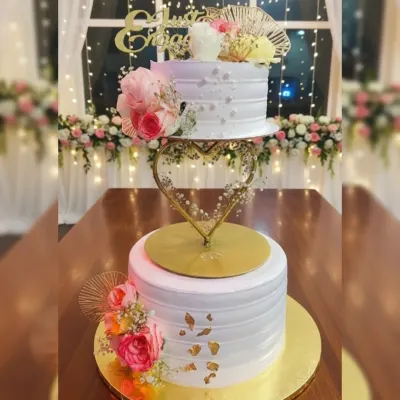 I love how a spacer can add so much elegance to a tiered cake. This two-tier engagement cake features a heart-shaped spacer, fresh florals, and gold leaf accents on a delicious eggless pineapple cake.