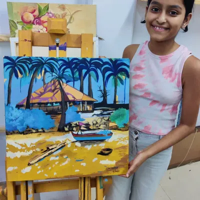 A proud moment for a young artist with her completed beachscape painting. Our classes for teens help them tackle more complex subjects and develop their personal style.