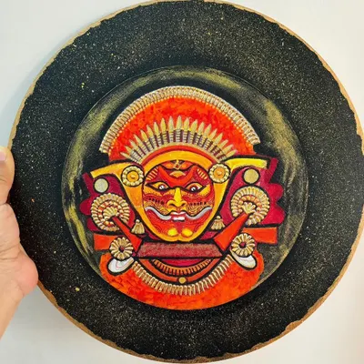 This Theyyam wall plate captures the fierce and divine expression of the ritual dancer. I used a textured black background with gold dust to evoke the mystical atmosphere of a performance by firelight.