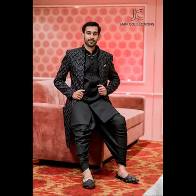 This black on black Indo-Western outfit is the definition of suave. The textured jacket paired with draped dhoti pants is a sharp, modern look for any evening event.
