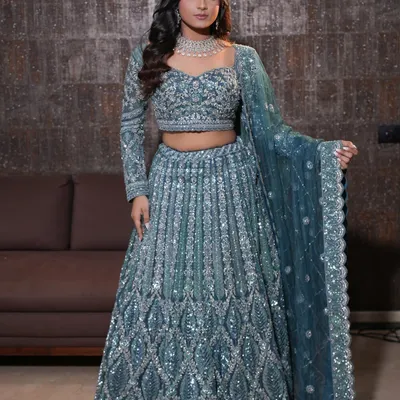 A full view of the stunning emerald green and silver lehenga. The makeup, with its pop of green liner and glowing skin, was designed to perfectly complement the entire ensemble for a sangeet or engagement night.