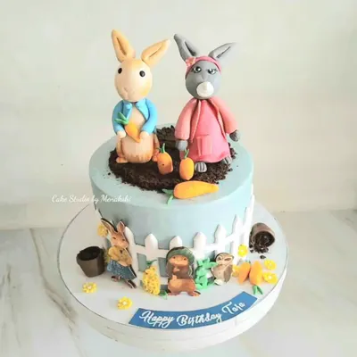 A charming Peter Rabbit themed cake for a little one's birthday. This design features hand-crafted figures of Peter and his friends in their garden, bringing the classic story to life.