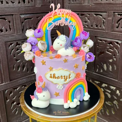 This magical unicorn and rainbow cake is one of my most popular designs for kids. It features two handmade fondant unicorns, colorful rainbows, and pretty flowers on a pastel purple buttercream base.
