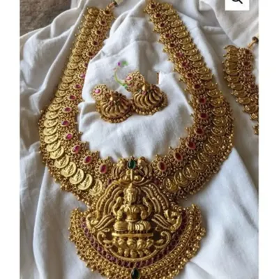 This stunning long haaram features a large goddess Lakshmi pendant and is adorned with coins and kemp stones. It's a perfect statement piece to rent for a wedding or major festival.