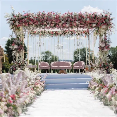 This magnificent floral stage is one of our signature designs for a grand engagement. The lush arch of pastel flowers, paired with elegant seating and a clean white stage, creates a picture-perfect backdrop for your special announcement.