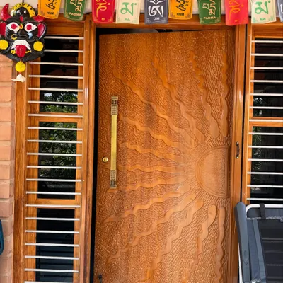 The main door is the first welcome to your home. For this farmhouse, we designed a custom teak wood door with a beautiful hand-carved sun motif, making a memorable first impression.
