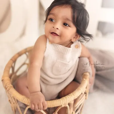 The sitter session is my favorite. This little one, sitting up confidently in a wicker basket, shows off his bright, happy personality. This age is full of smiles and curiosity.