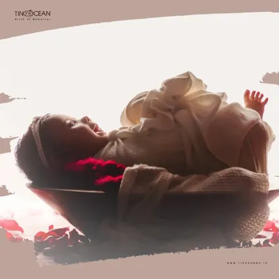 An artistic newborn portrait capturing a moment of pure bliss. The soft backlighting and dreamy edit, combined with rose petals, create a beautiful and ethereal image of this baby girl.