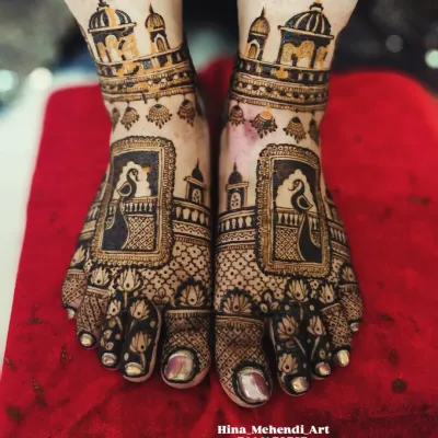 A stunning bridal feet design featuring peacocks within ornate frames and architectural domes on the ankles, creating a royal look.