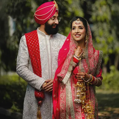 A candid moment between the bride and groom during their outdoor portrait session. The groom's loving gaze captures the essence of their Sikh wedding day.