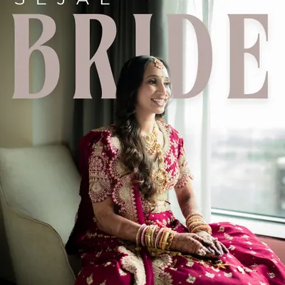 A portrait of the bride, Sejal, seated by the window. The natural light beautifully illuminates her intricate red lehenga and her serene, happy expression.