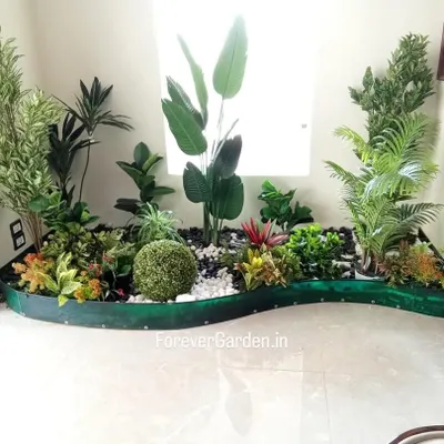 A beautiful, custom-designed indoor garden bed filled with a variety of artificial plants, including ferns, palms, and tropical foliage, creating a stunning focal point.