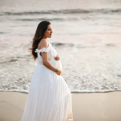 A serene solo portrait on the beach. The soft evening light and the sound of the waves create a perfect backdrop for capturing the peaceful and powerful journey of motherhood.