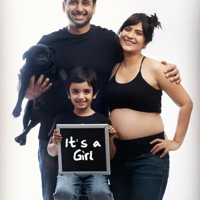 The whole crew is ready! This fun family portrait includes the soon-to-be big brother and the family pug, announcing "It's a Girl!" with a cute chalkboard sign.