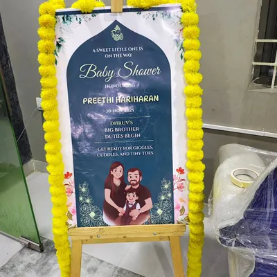 A personalized welcome sign for a baby shower, placed on a wooden easel. I decorate the sign with traditional marigold flowers to match the event's theme.