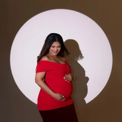 Using a single spotlight, I can create a sense of drama and focus entirely on the mother-to-be. This portrait of Ruchika in a bold red dress is a perfect example of how simple, powerful lighting can create a striking and elegant maternity photo.