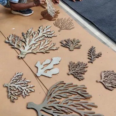 The process of creating our coral awareness installation. Here, our team is laying out the laser-cut coral shapes before assembling them onto the main panel. Every piece was carefully designed to represent different types of coral, creating a rich and detailed texture.