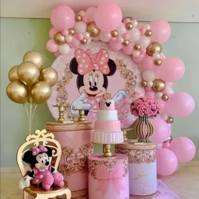 A charming and regal Minnie Mouse themed birthday party. The pink and gold color scheme, ornate pedestals, and a special chair for the birthday girl give this classic character theme a royal princess feel.