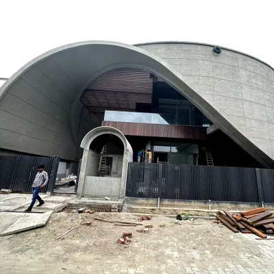 This family home in Haryana is a modern monolith, defined by its striking curves and raw concrete finish. The design is both commodious and cavernous, with the facade coming to life as a massive, sculptural form that commands attention.