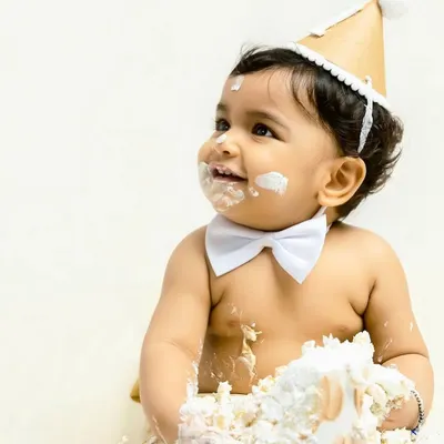 The pure joy of turning one. This little boy, wearing a smart bowtie, is all smiles as he digs into his first birthday cake. This is the classic, happy mess I love to capture.