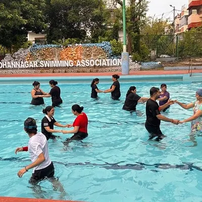 A group of adults enjoying a partnered dance move during our aqua fitness class. The water provides support, making it great for all fitness levels.