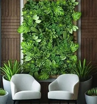 This framed vertical garden serves as a living piece of art. The dense arrangement of artificial monsteras and succulents creates a rich, three-dimensional texture that becomes the focal point of the room, perfectly complementing the modern seating area.