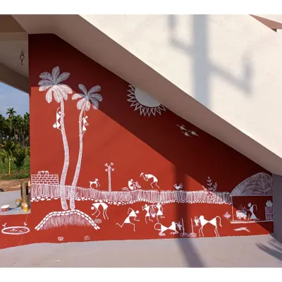 This wide-angle shot shows the full scale of a Warli mural I painted under a staircase. The composition fills the entire angled wall, depicting a lively village scene with palm trees, animals, and people engaged in various activities.