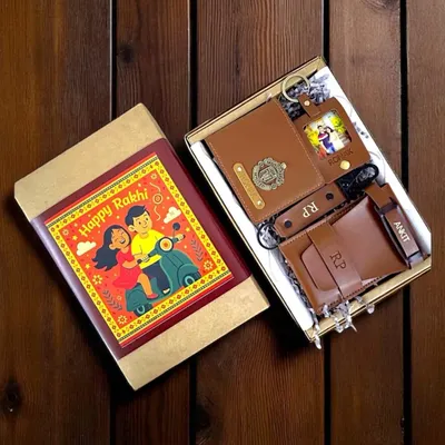 This Rakshabandhan hamper for a brother is packed with personalized vegan leather goods. It includes a wallet, passport cover, and keychains, all customized with names, initials, and charms, presented in a festive box.