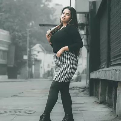 A full-length street style shot from my winter series. The houndstooth skirt and combat boots create a chic, edgy look against the gritty urban background, perfect for a model's portfolio showing commercial and editorial range.