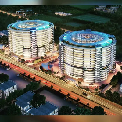 An aerial night view rendering of twin towers designed for a 7-star resort and serviced apartment complex in Surat. The radial design and illuminated crowns are engineered to make this a standout destination.