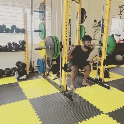 A member executes a deep squat inside the power rack, a core exercise in our program for building overall strength and leg power.
