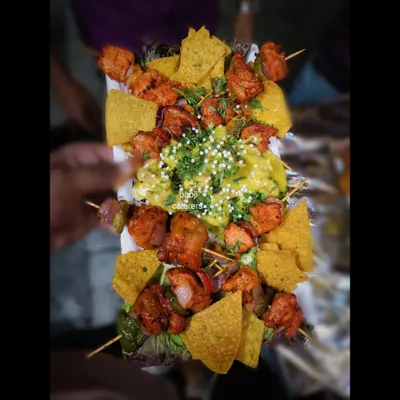 Our Chicken Shashlik with Lebanese chicken, served with nachos. This dish is a fusion of flavors, combining tender grilled chicken with a creamy sauce and crunchy nachos.