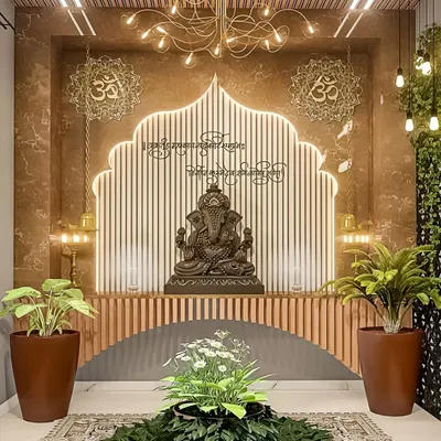 We designed this contemporary pooja space to be both serene and stylish. The design features a custom arch with LED backlighting against a fluted wood panel, a modern chandelier, and strategically placed plants to create a tranquil, nature-inspired ambiance for a Ganesha idol.