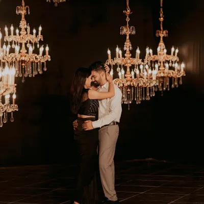 A couple shares an intimate dance, surrounded by a constellation of hanging crystal chandeliers. This shot exemplifies a glamorous and romantic indoor pre-wedding theme.