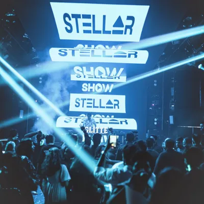 A view from the dance floor at Glitte, with my logo stacked high on the screen and light beams cutting through the haze. This is what an immersive visual experience looks like.