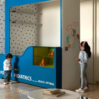 At the "Plug & Play" clinic, we designed the reception desk to be an interactive hub for children. The low counter, display niches, and an adjacent whiteboard wall encourage creativity and play, helping to ease the anxiety of a doctor's visit.