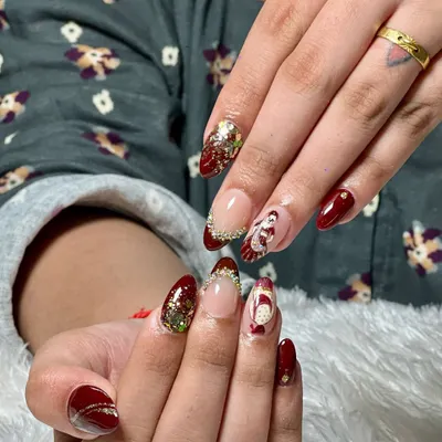 For our brides, we create truly one-of-a-kind nail art. This custom set for a wedding features a deep maroon base, sparkling glitter accents, and a hand-painted traditional bride design, making it a memorable part of the special day.