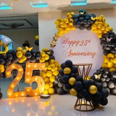 A grand 25th anniversary celebration featuring a striking black and yellow balloon arch, matching balloon pillars, and large marquee numbers. The color scheme is bold and celebratory, perfect for a major milestone.